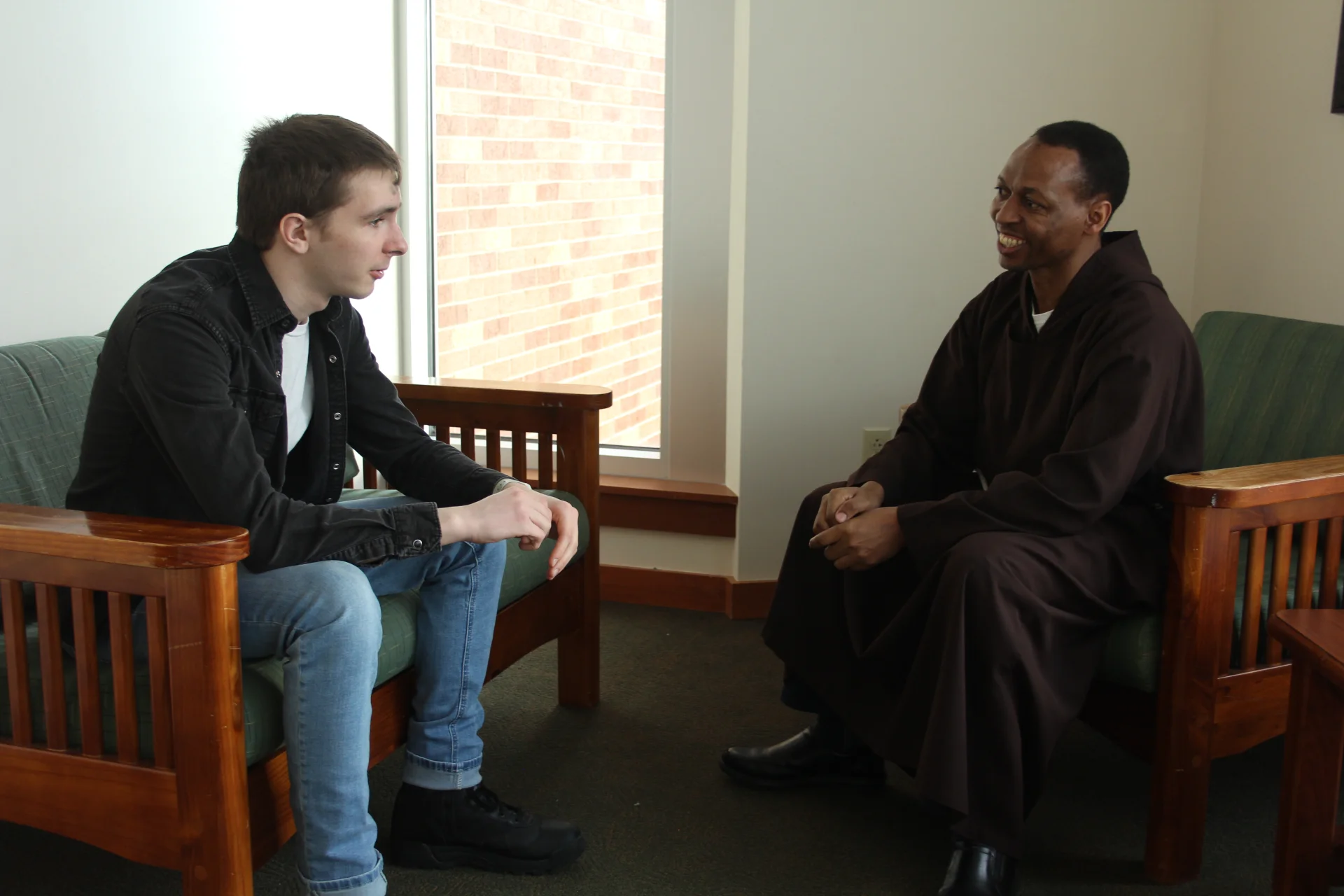 Student speaking with a priest